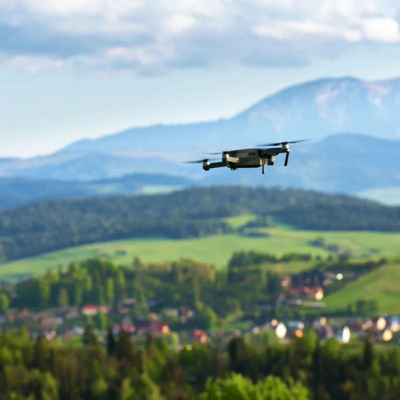 Drone with camera flying over mountain fields. Aerial photography and videography. Drone quad copter with high resolution digital camera in the air